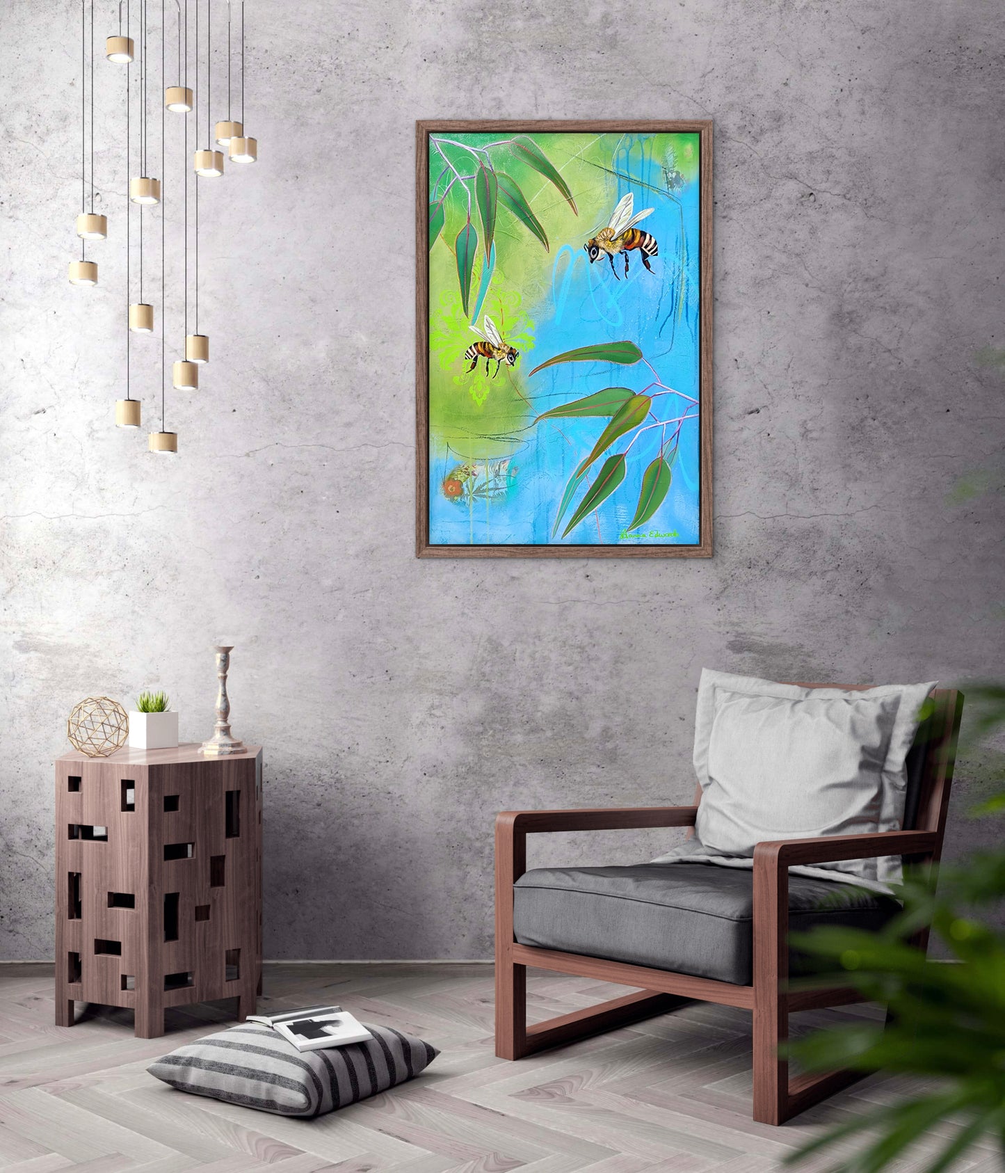 Framed artwork of bees and leaves on a wall above a chair in a room.