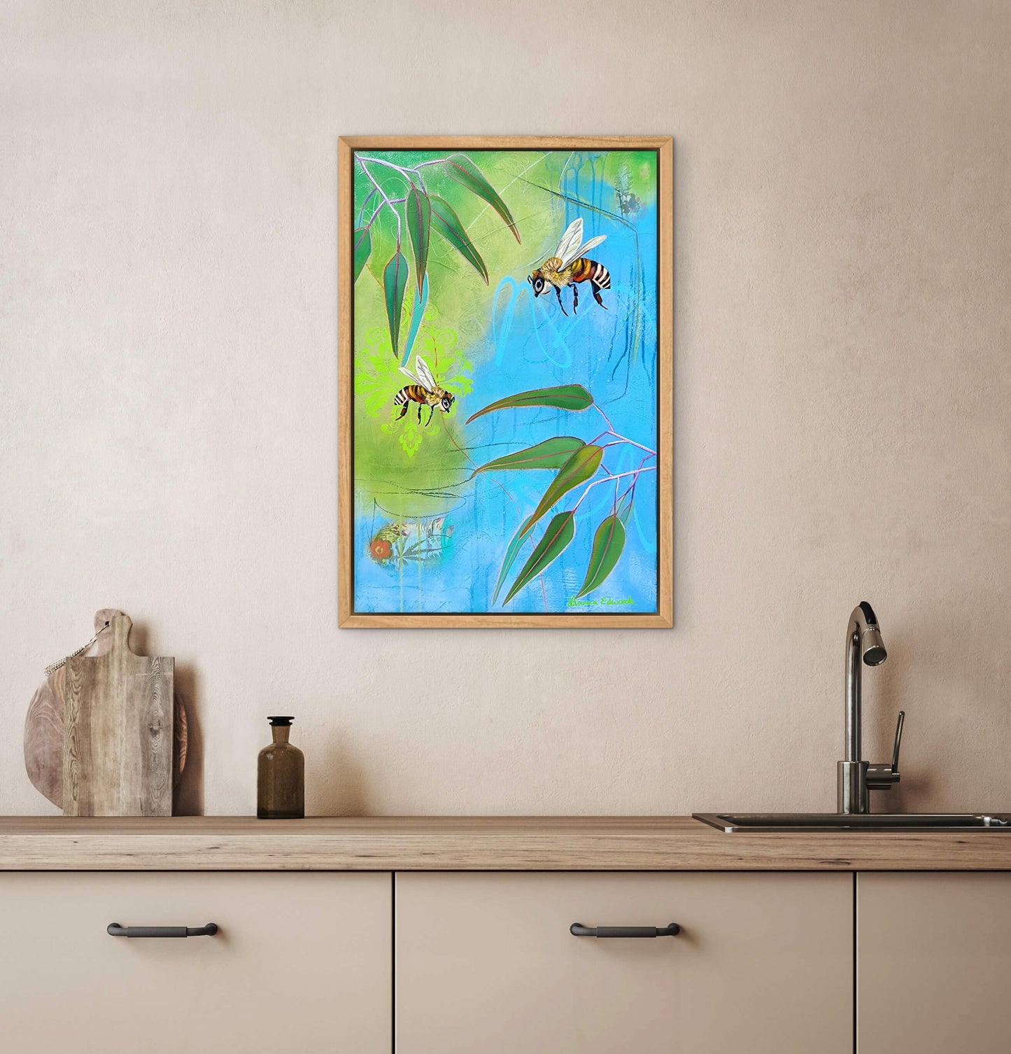 Framed artwork of bees and leaves on a kitchen wall