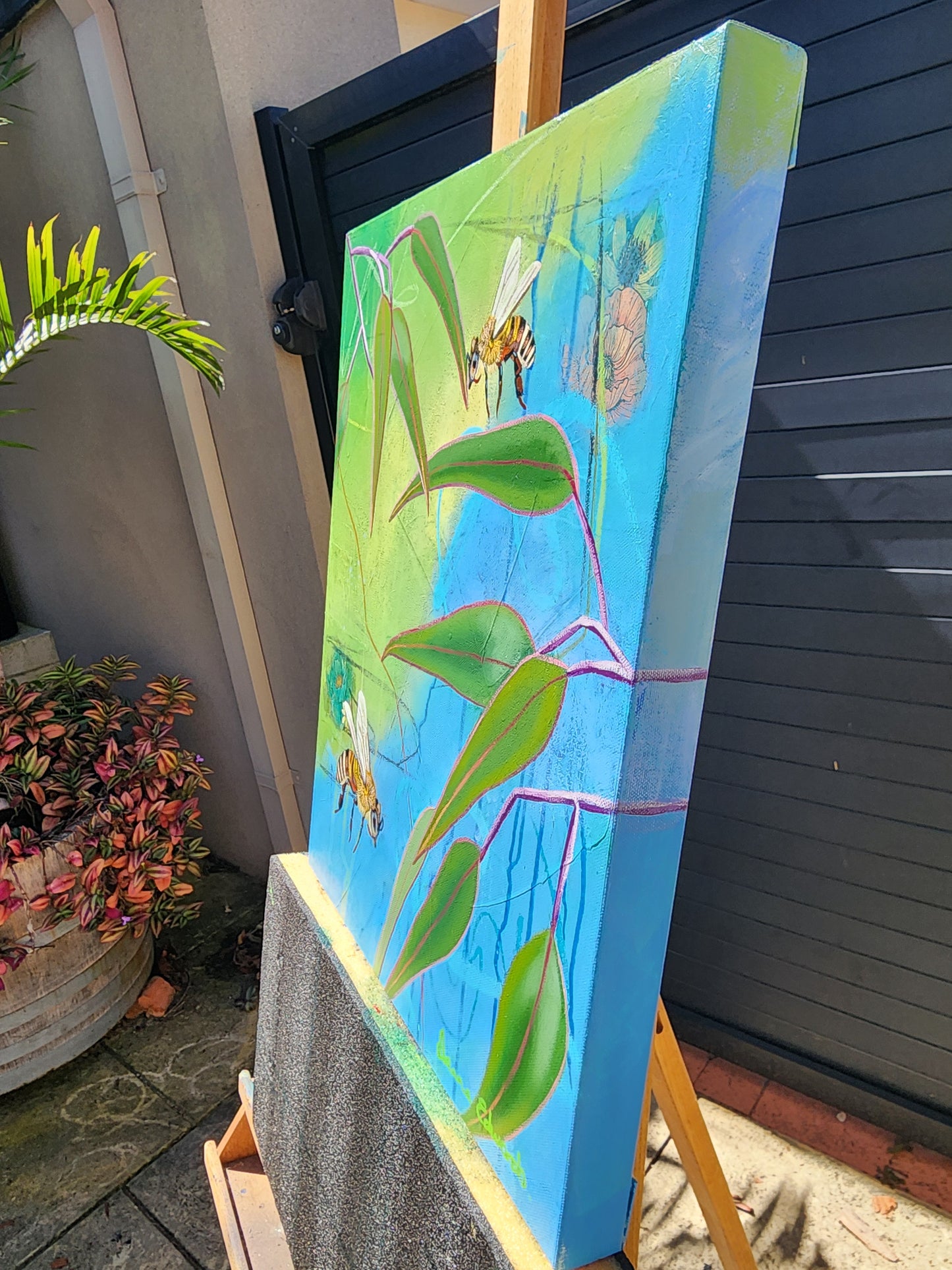 Painting side view on an easel outdoors.