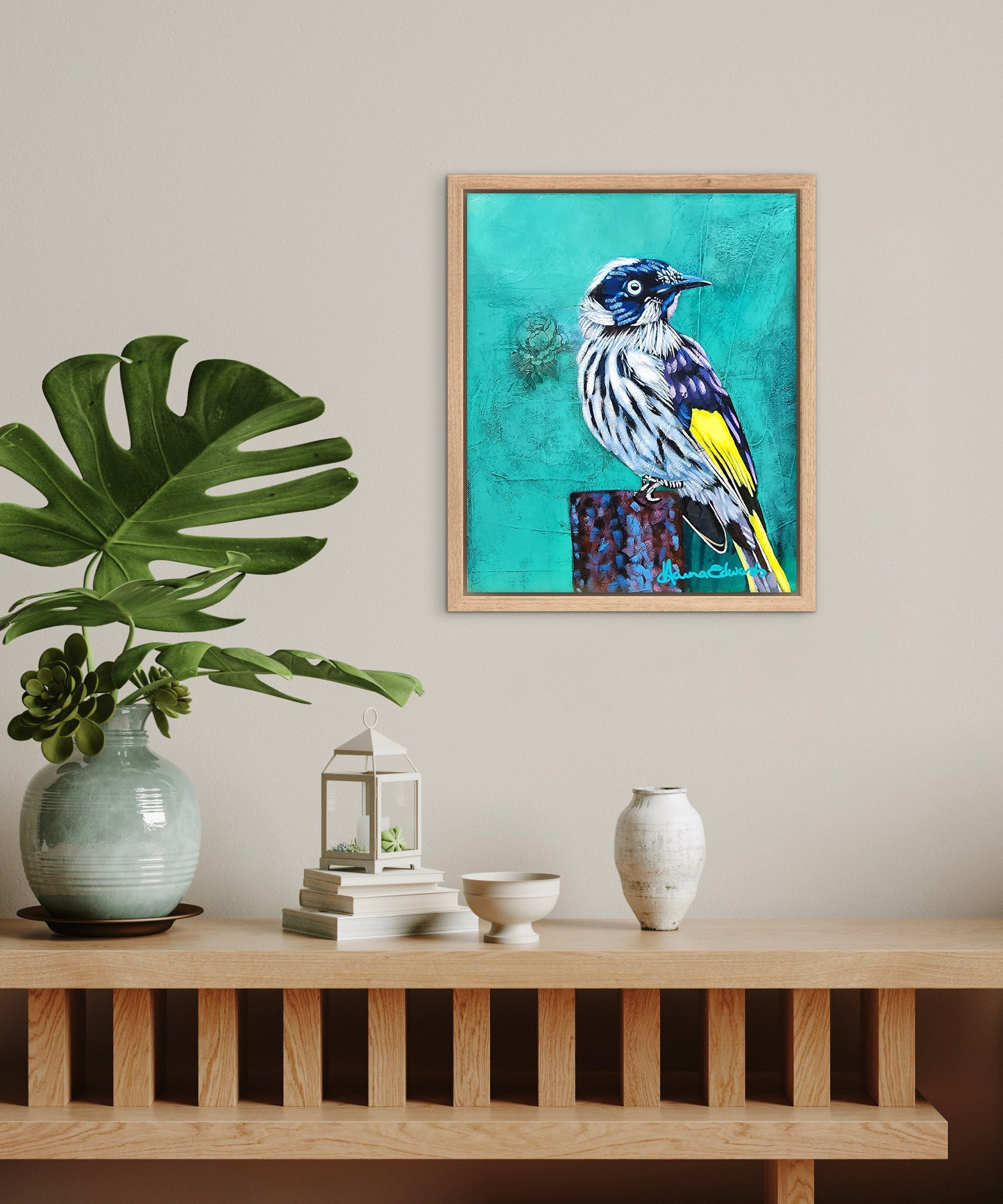 Framed artwork of a bird on a wall above a wooden console table with decorative items.