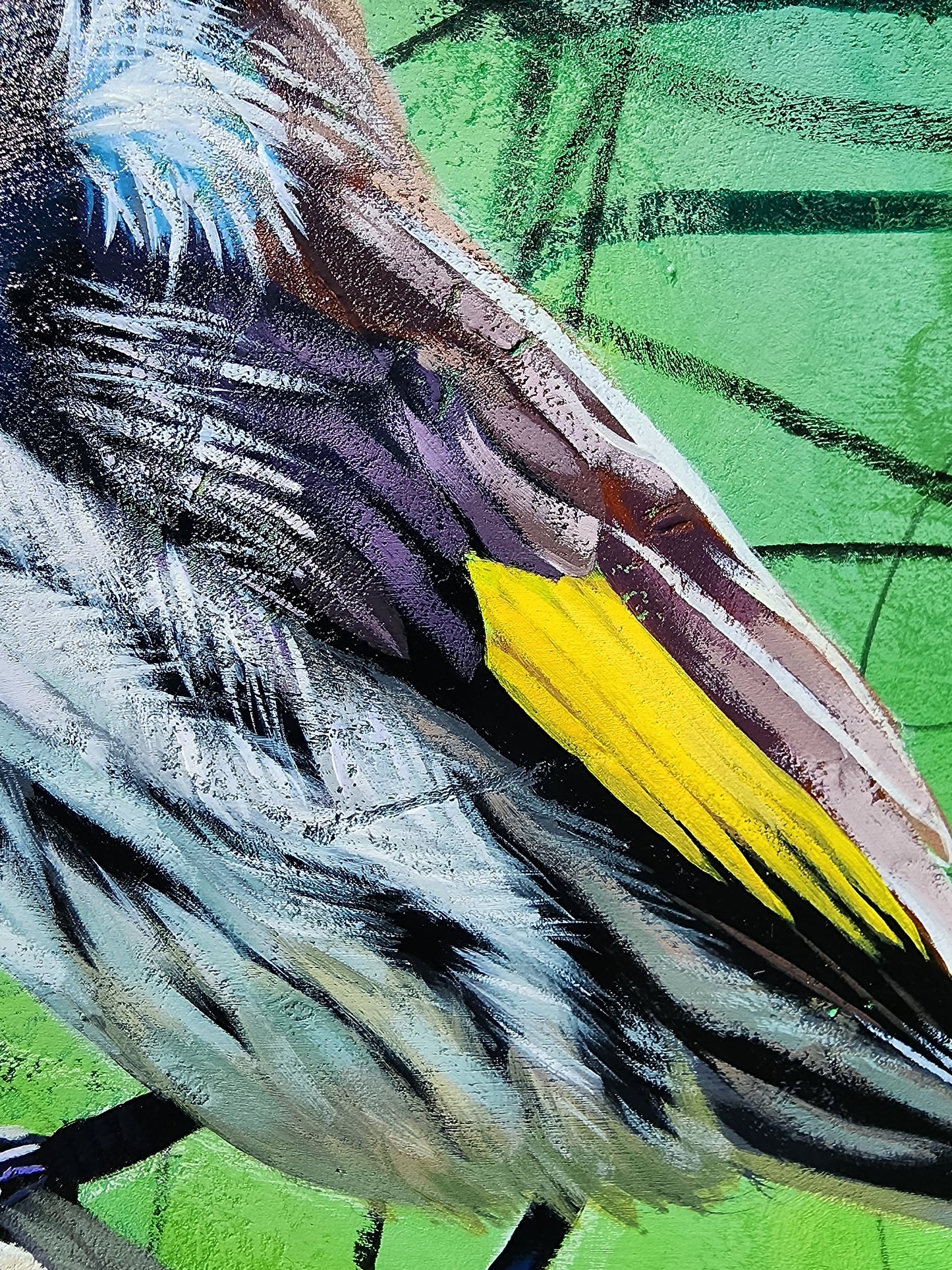 Close-up of a bird with a yellow wing against a green background