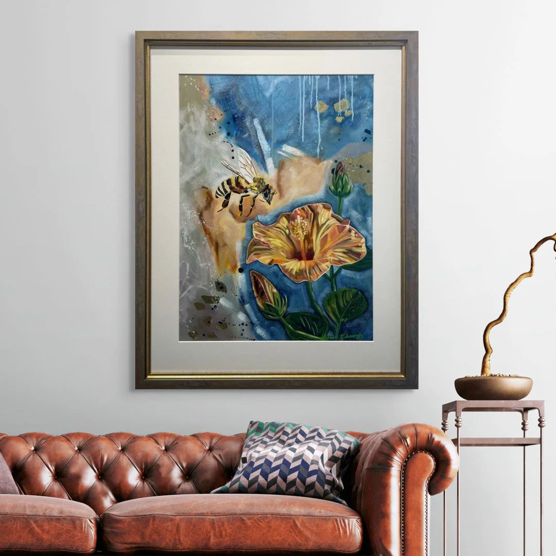 Framed abstract artwork on a wall above a brown leather sofa with decorative pillows.