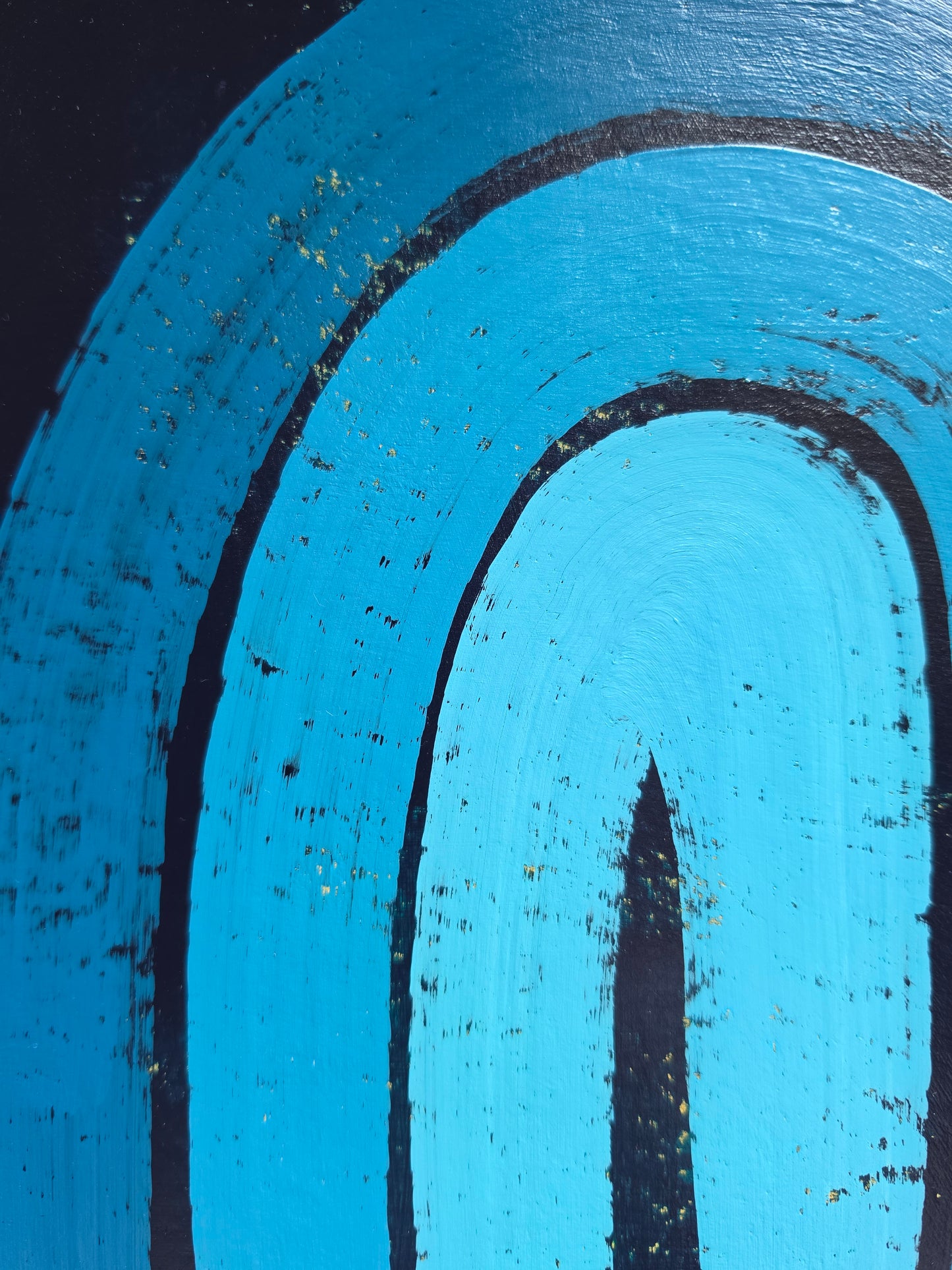 A blue painting with pops of yellow underneath with a white border featuring a blue  textured rainbow design 