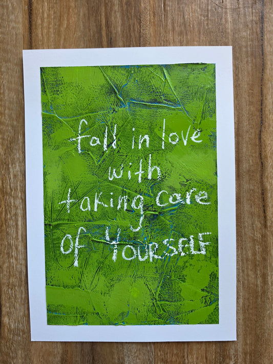 Abstract painting with green textured background and white text Fall in love with taking care of yourself on a  wooden surface