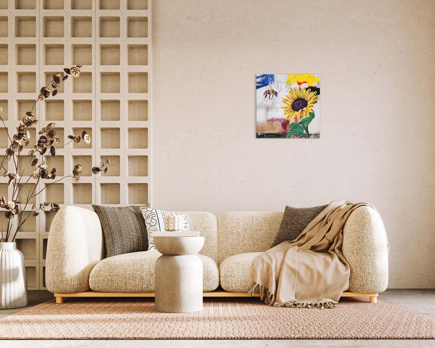 Living room with a beige sofa, decorative pillows, and a wall art piece featuring sunflowers and bees.