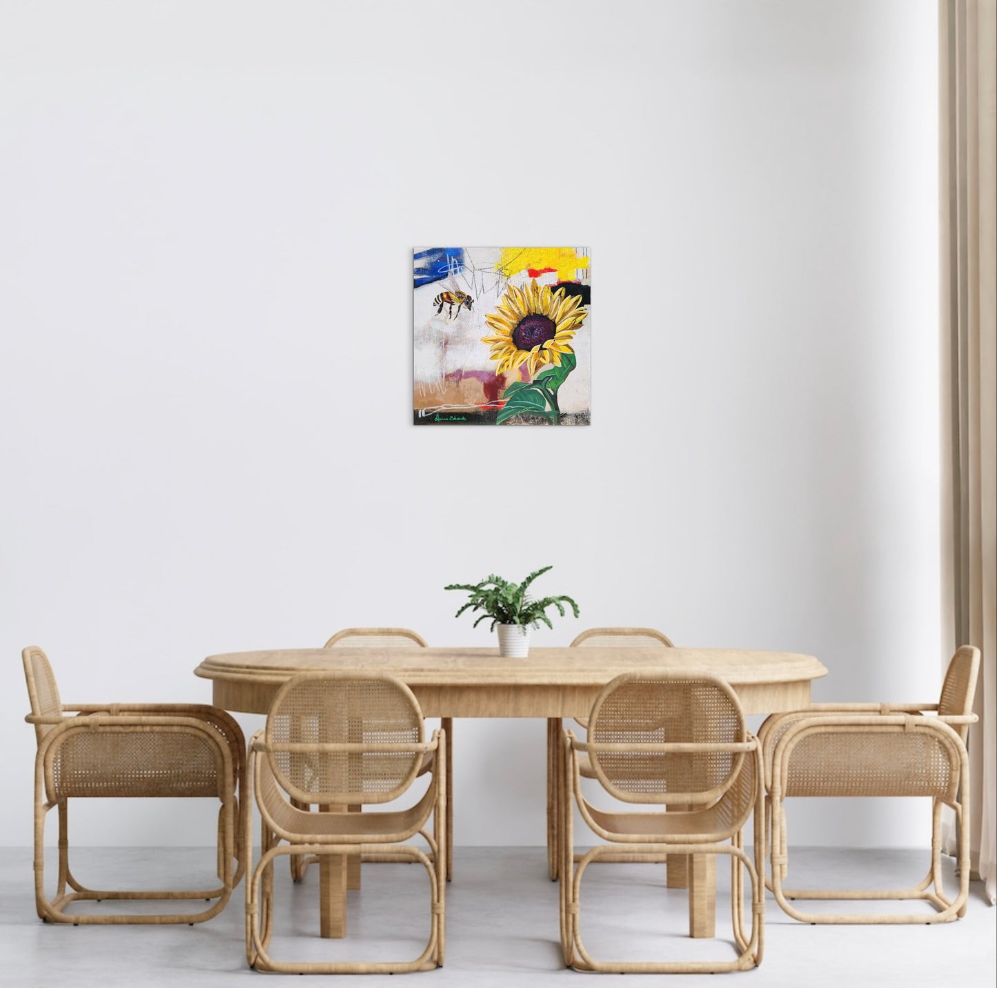 Dining area with wicker furniture and a colorful abstract painting on the wall.