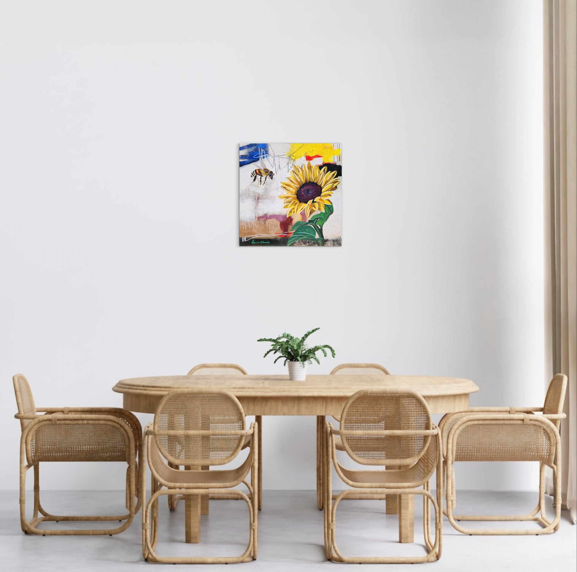 Dining area with wicker furniture and a colorful abstract painting on the wall.