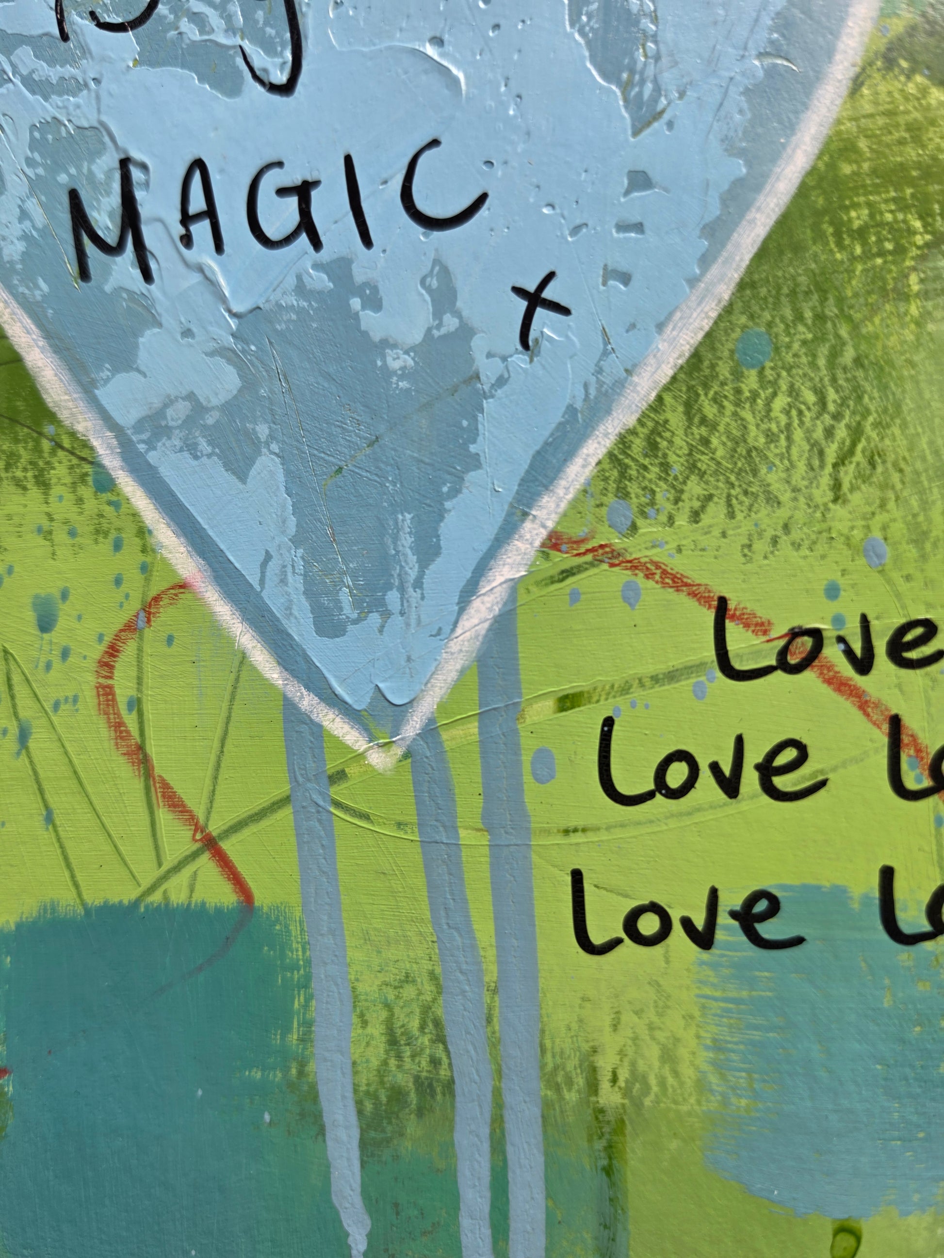 Close-up of a painting  with text 'Love' and 'MAGIC x' on a colorful background