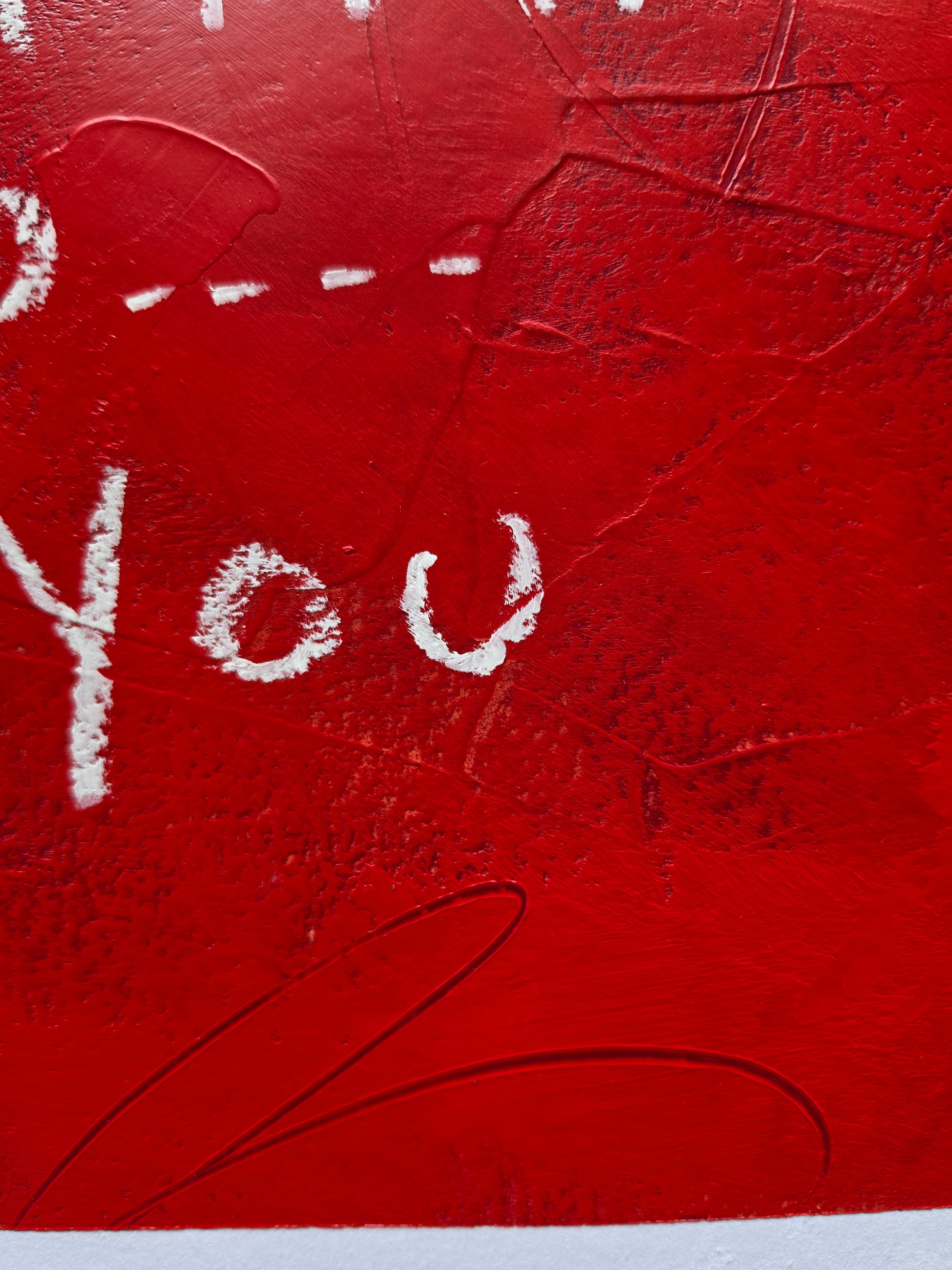 Red painting close up with white text and texture