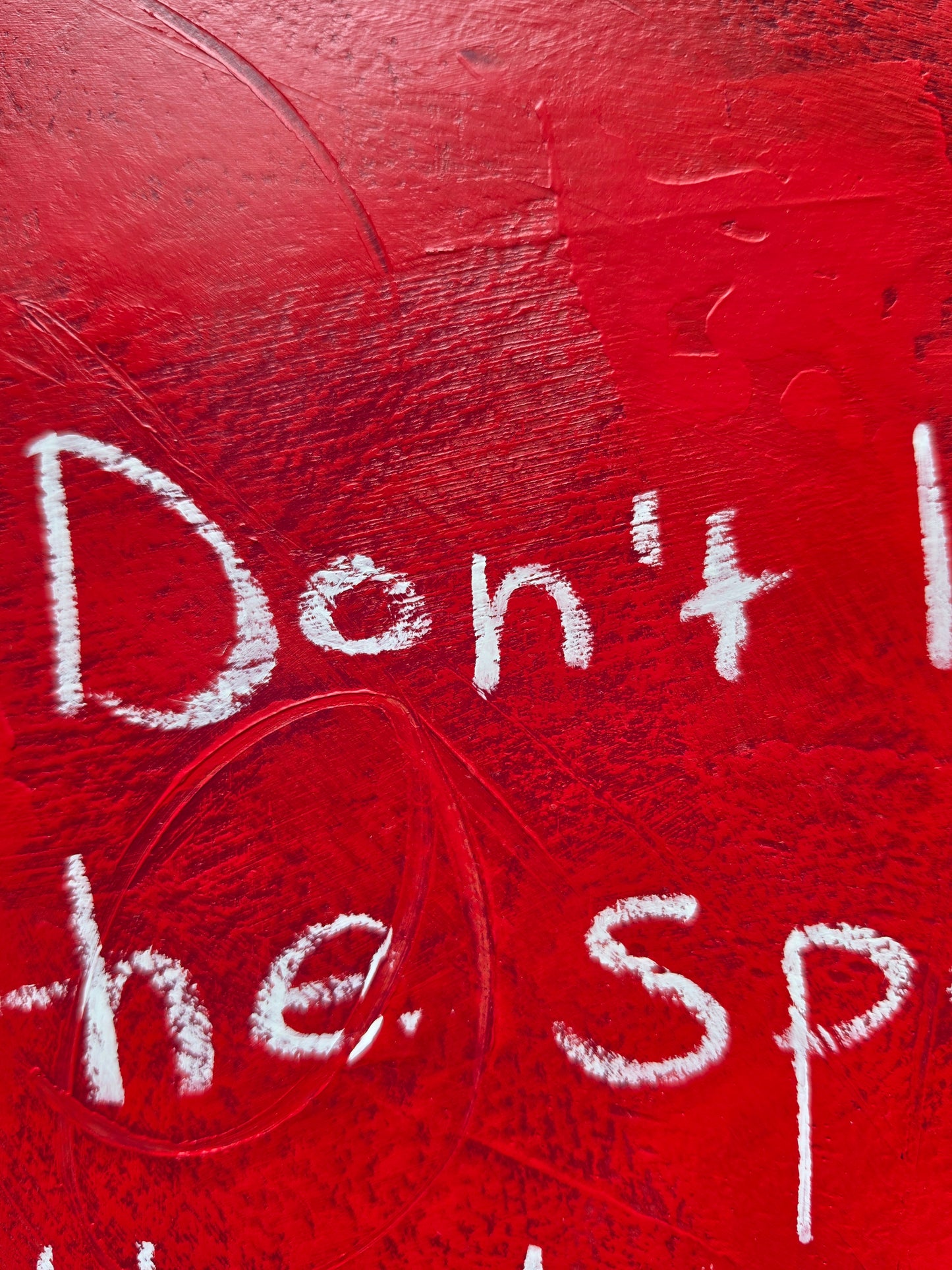 Red painting close up with texture and white text 