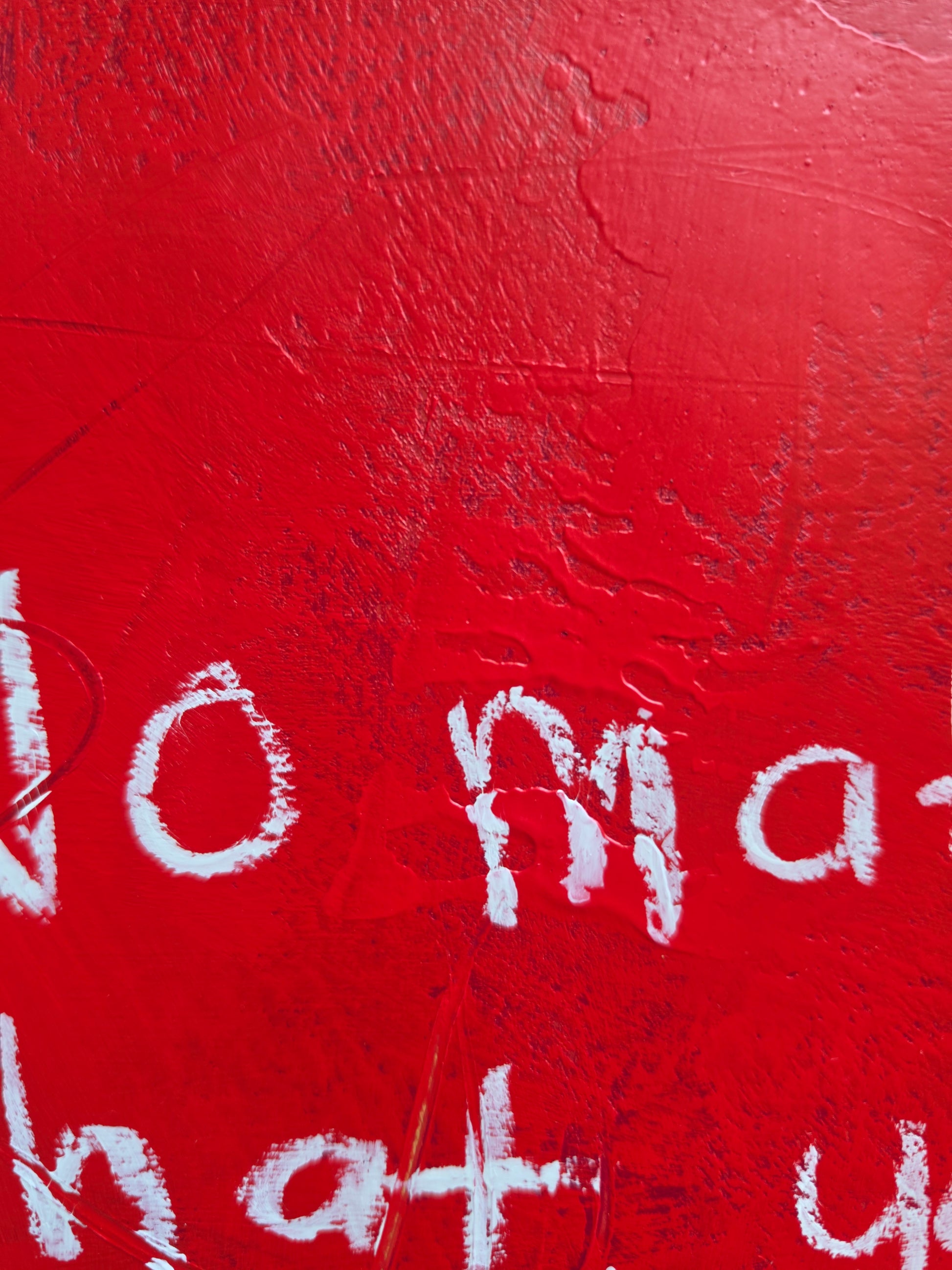 Close up of red painting with white text partially visible