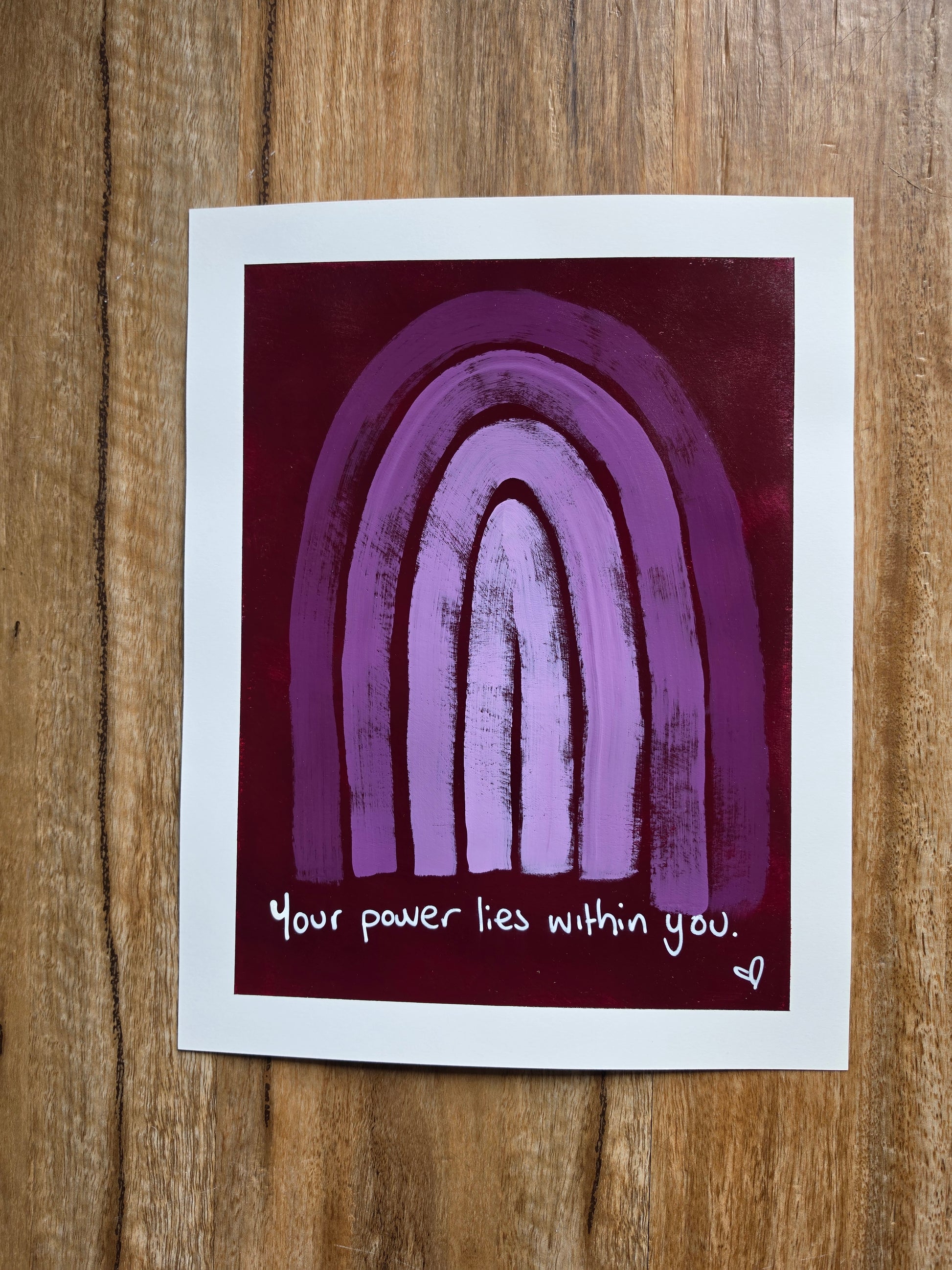 Painting purple/red with monochromatic purple rainbow with quote 'Your power lies within you.' on a wooden surface