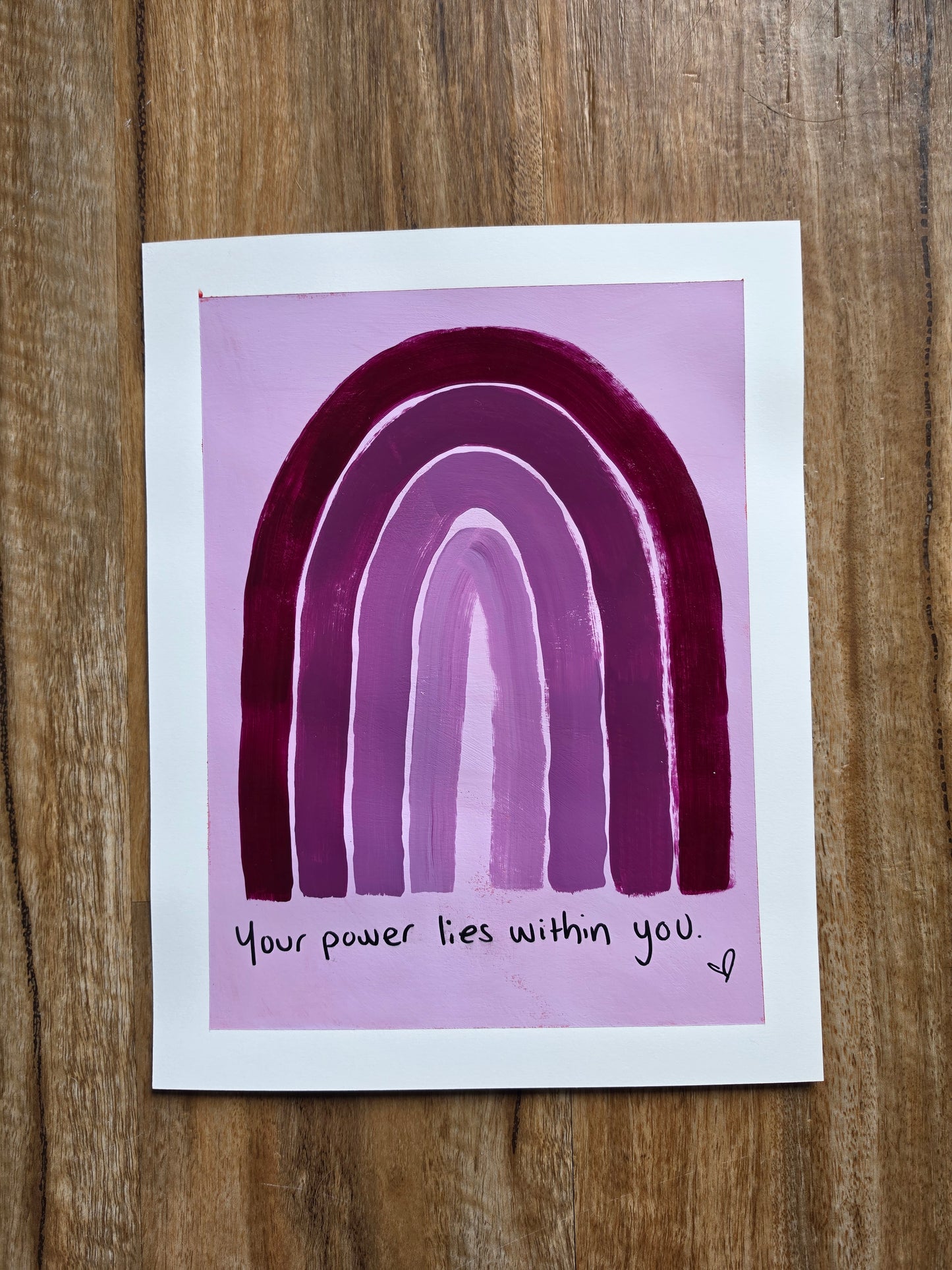 Purple rainbow painting with motivational quote your power lies within you on a wooden surface