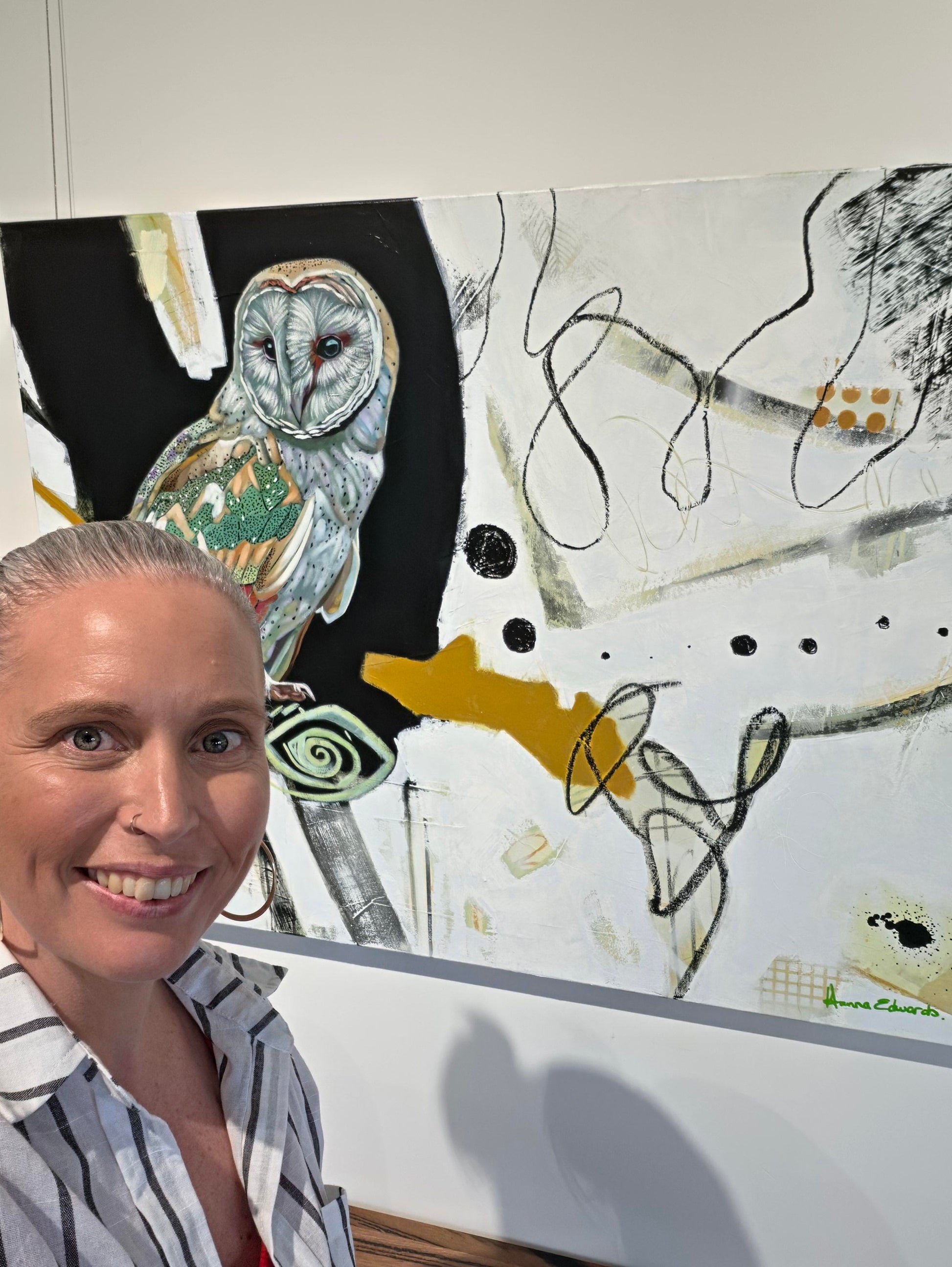 Owl painting hung on wall with artist Hanna Edwards