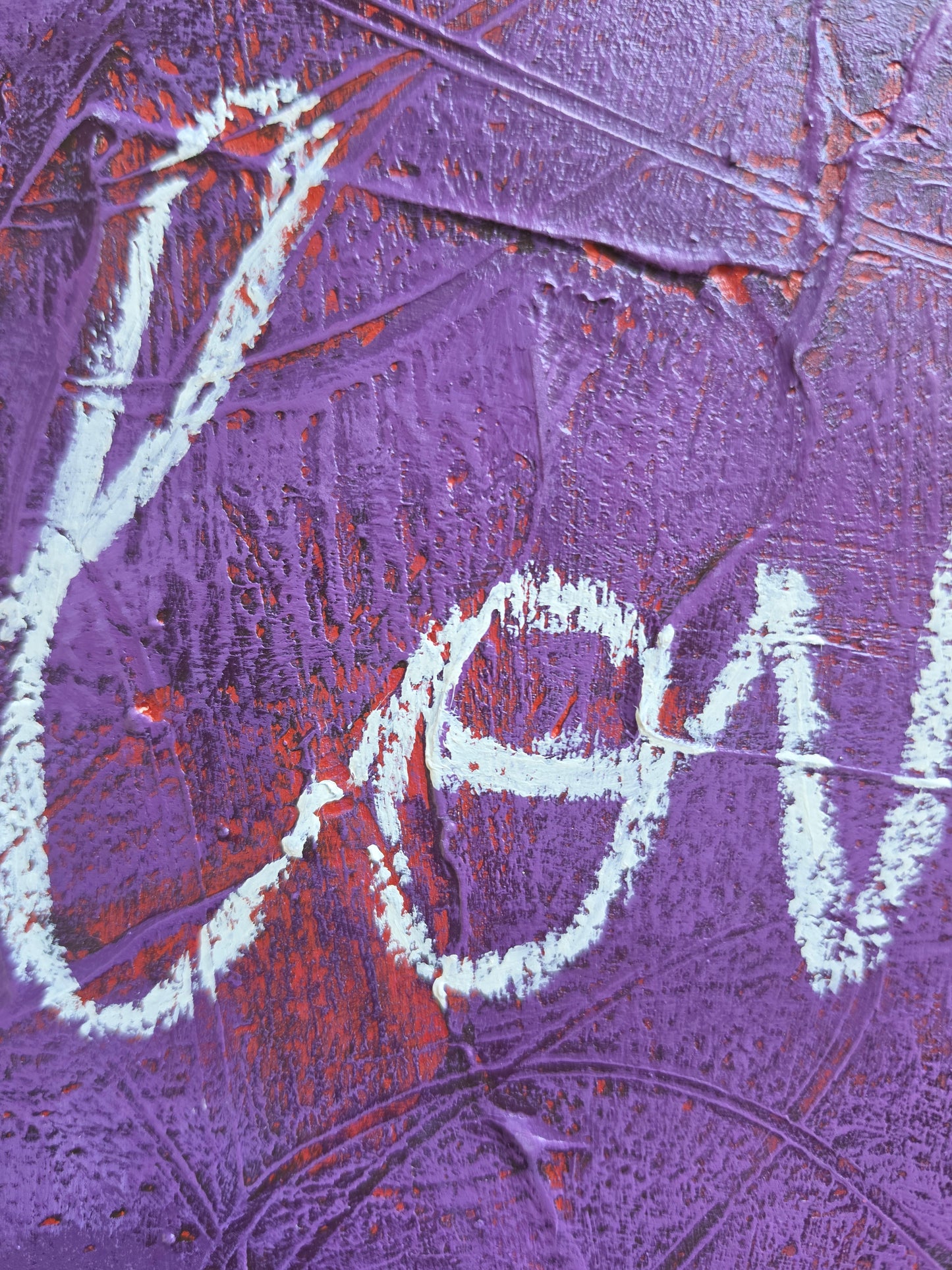 Heavily textured painting in purple with pops of red coming through with the word Love close up