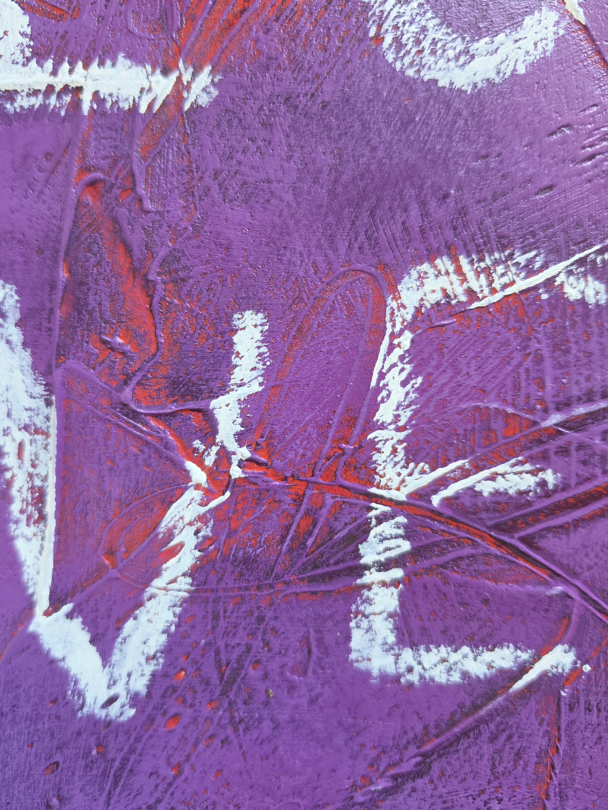 Heavily textured painting in purple with pops of red coming through with the word Love close up