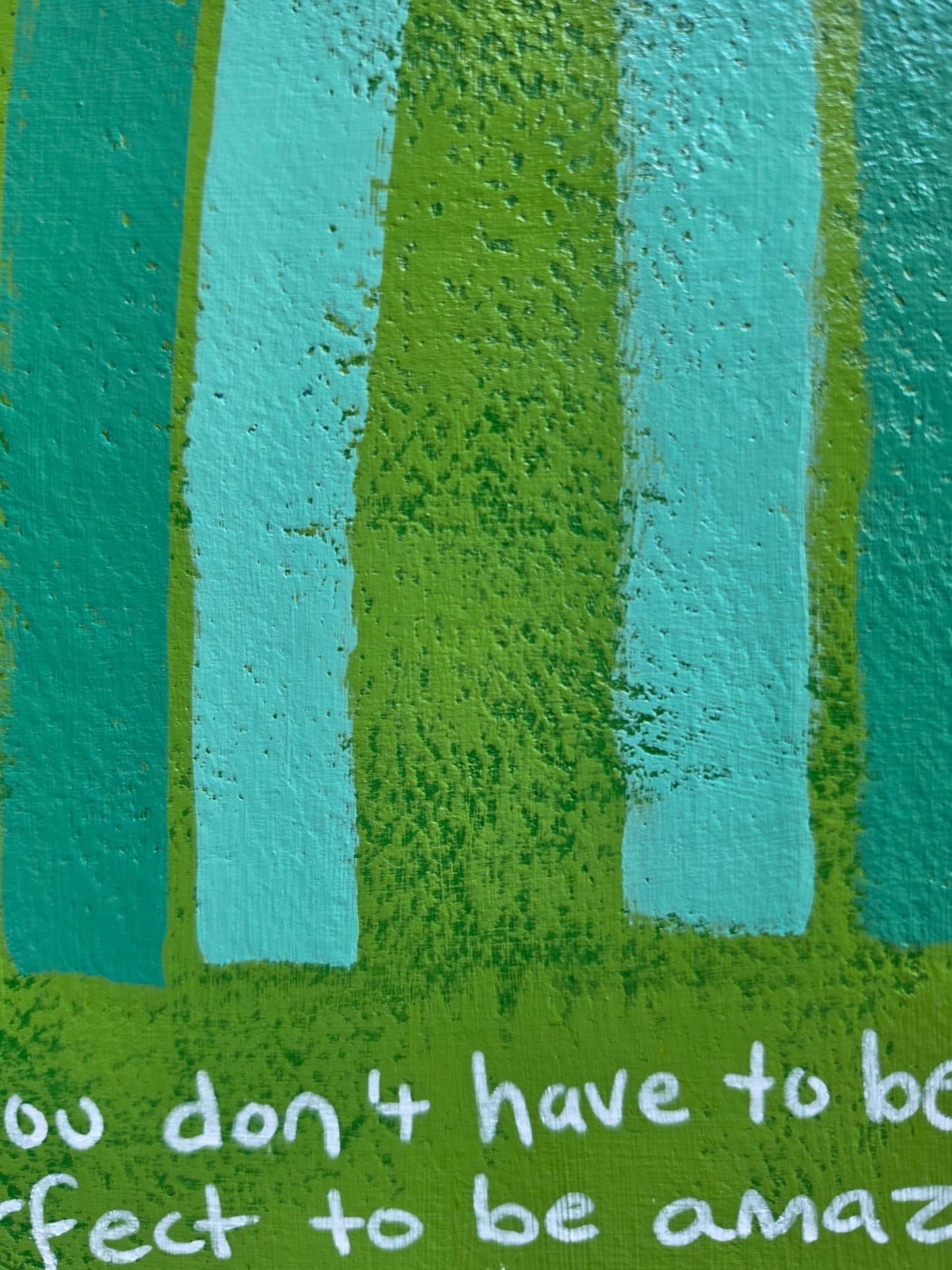 Green painting with monochromatic rainbow with the words You don't have to be perfect to be amazing in white handwriting close up