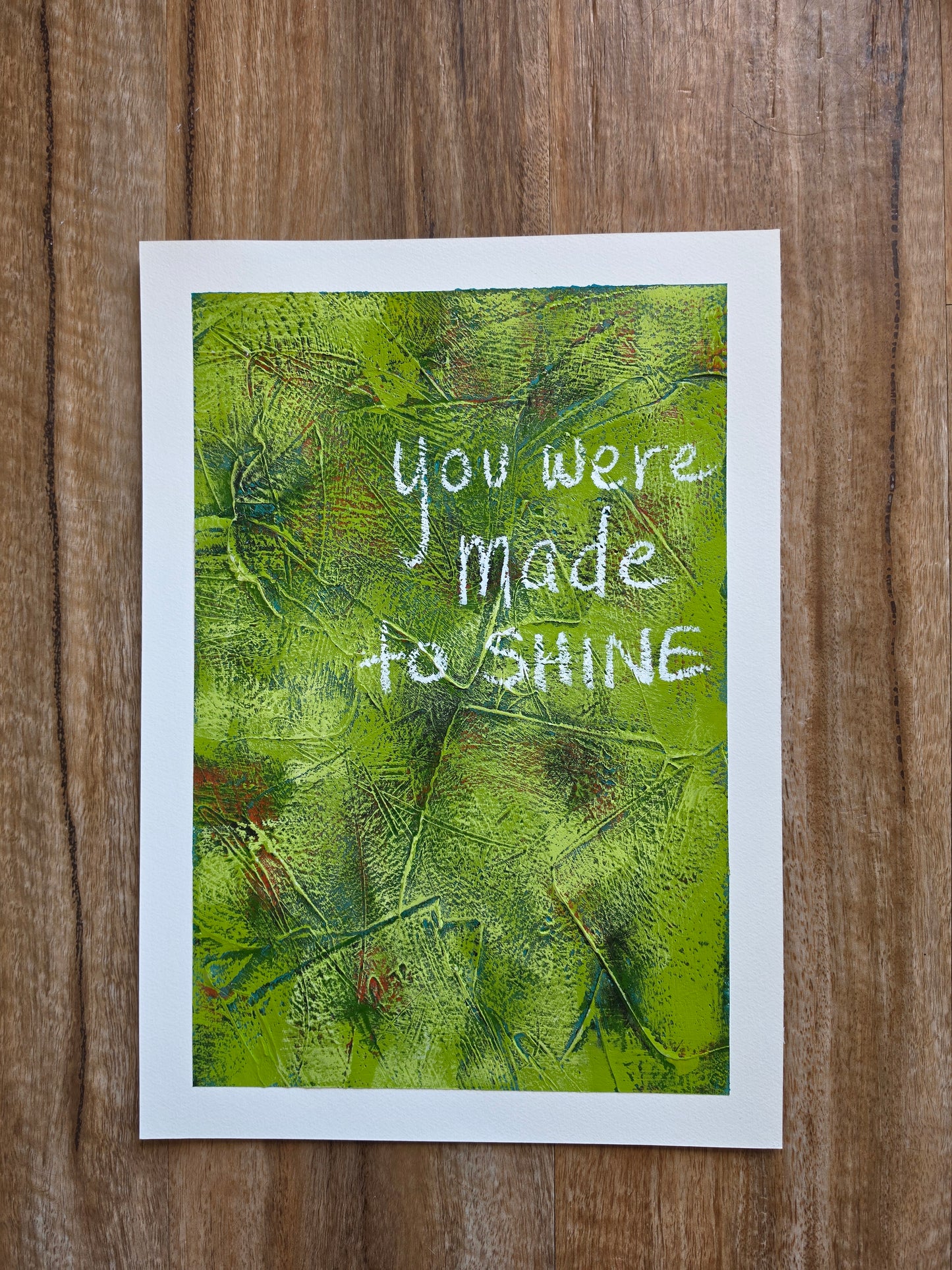 Abstract painting in green with pops of green , teal and red with the words You Were Made to Shine handwritten in white