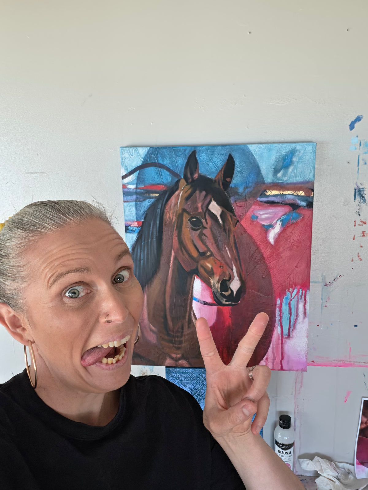Australian artist Hanna Edwards with one of her colourful horse paintings